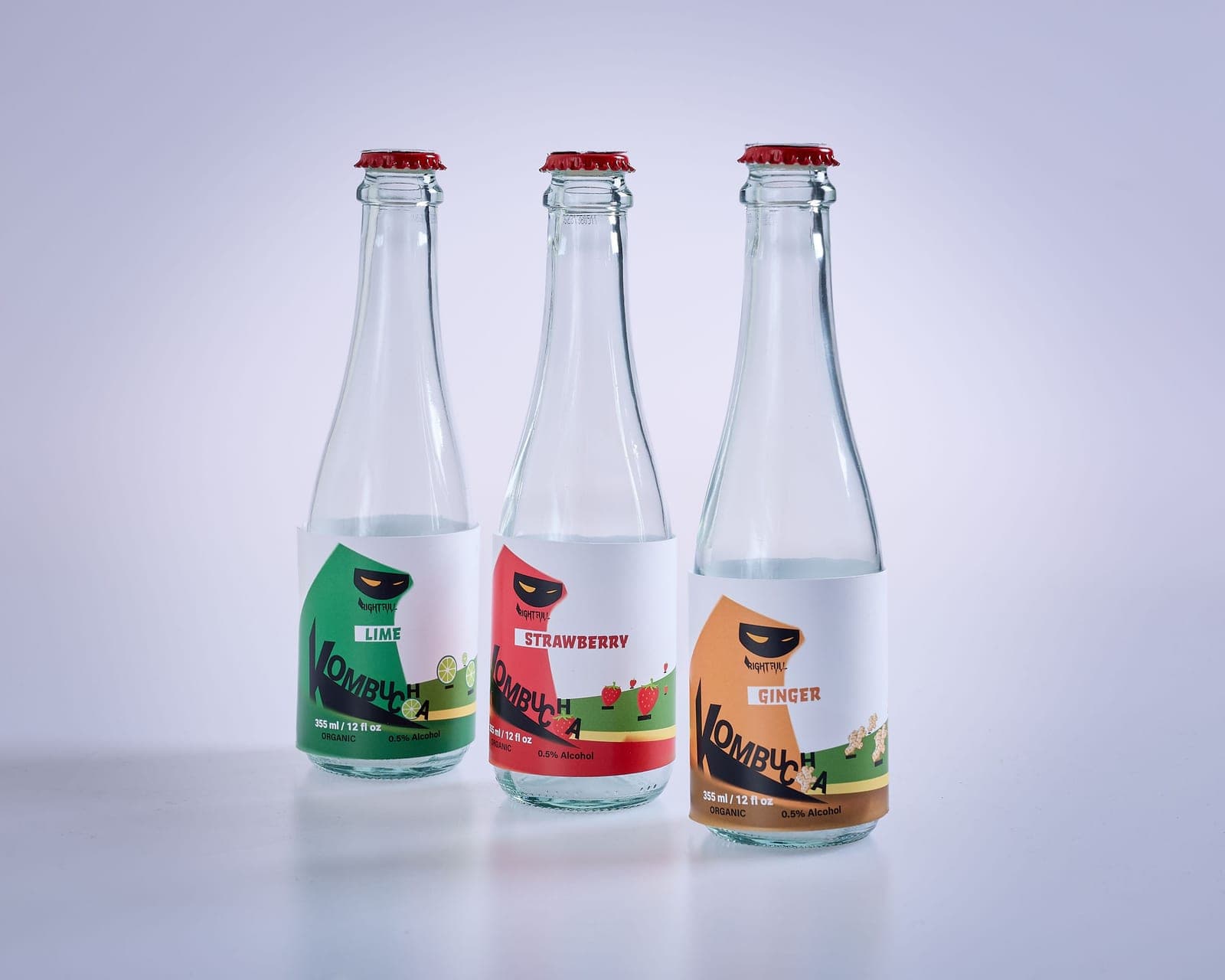 Bottles of fruit-flavored kombucha standing on a bright kitchen counter