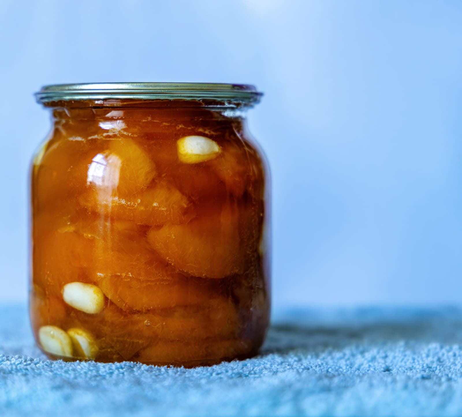 Pineapple peel in a glass jar of liquid on a bright surface