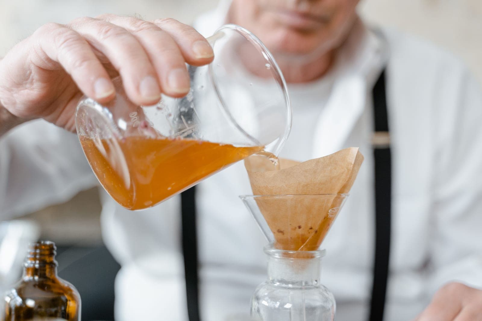 Liquid being poured through a funnel into a bottle