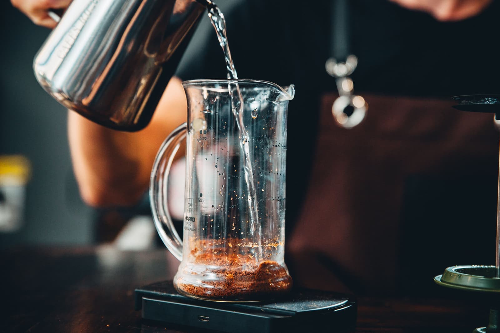 Tea being brewed in a large glass jug in a bright kitchen