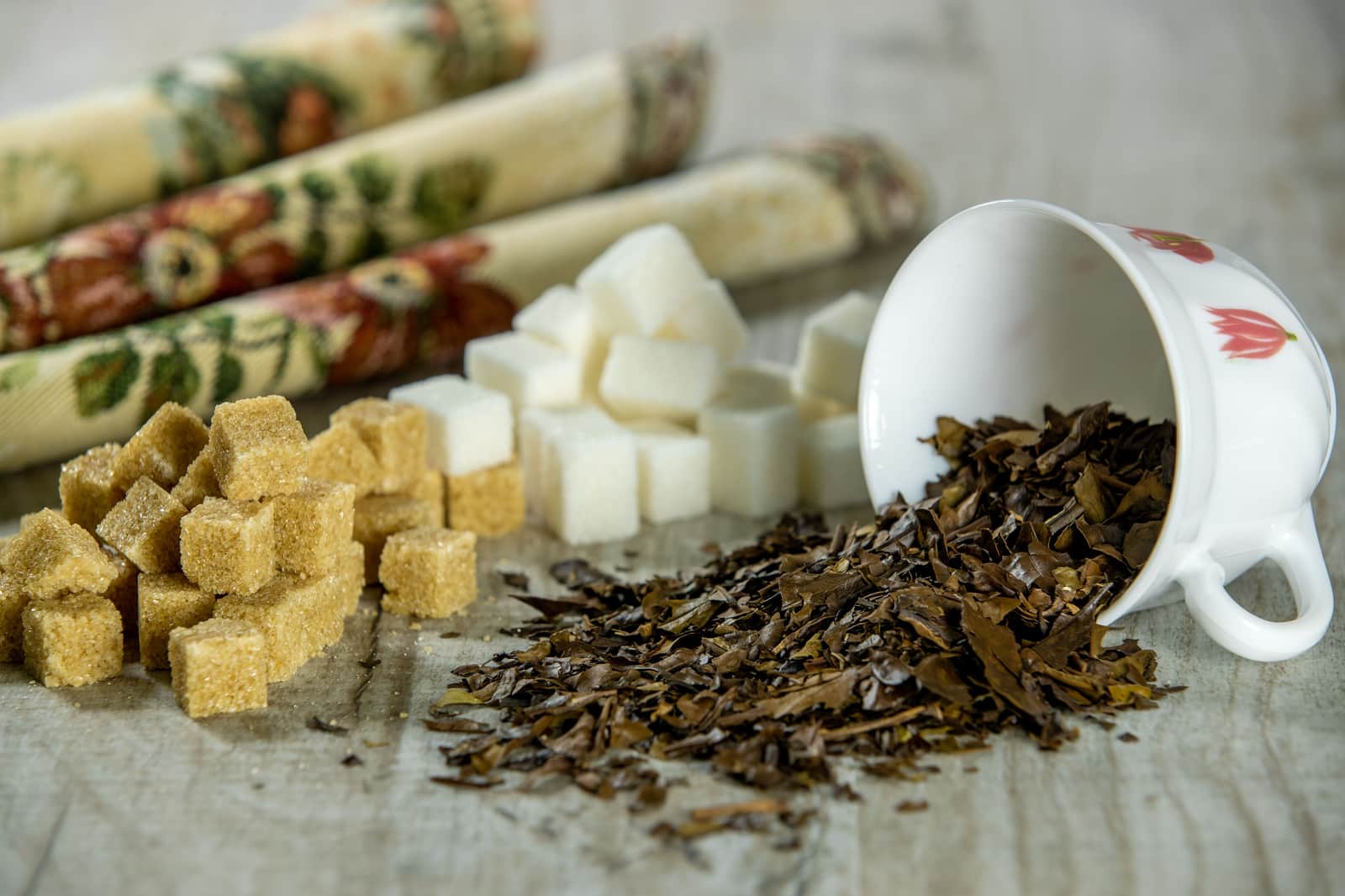 Loose leaf tea and sugar in white bowls on a bright surface